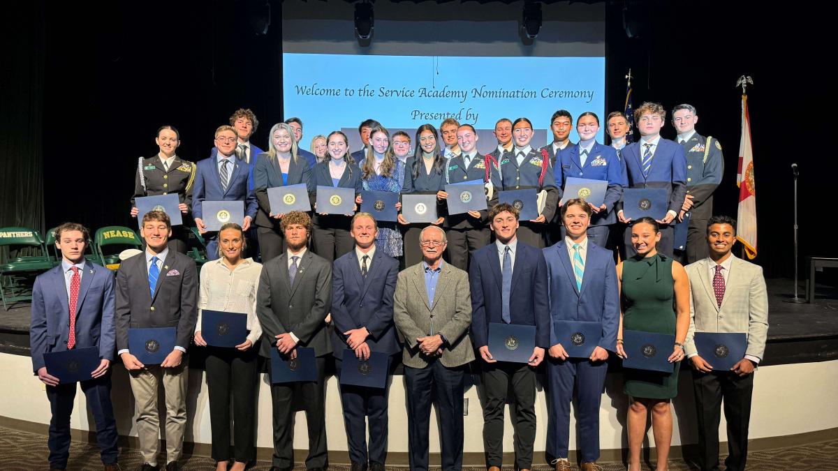 Congressman Rutherford with FL-05 Nominated Students in front of a stage with Rep.Rutherford in the Center.